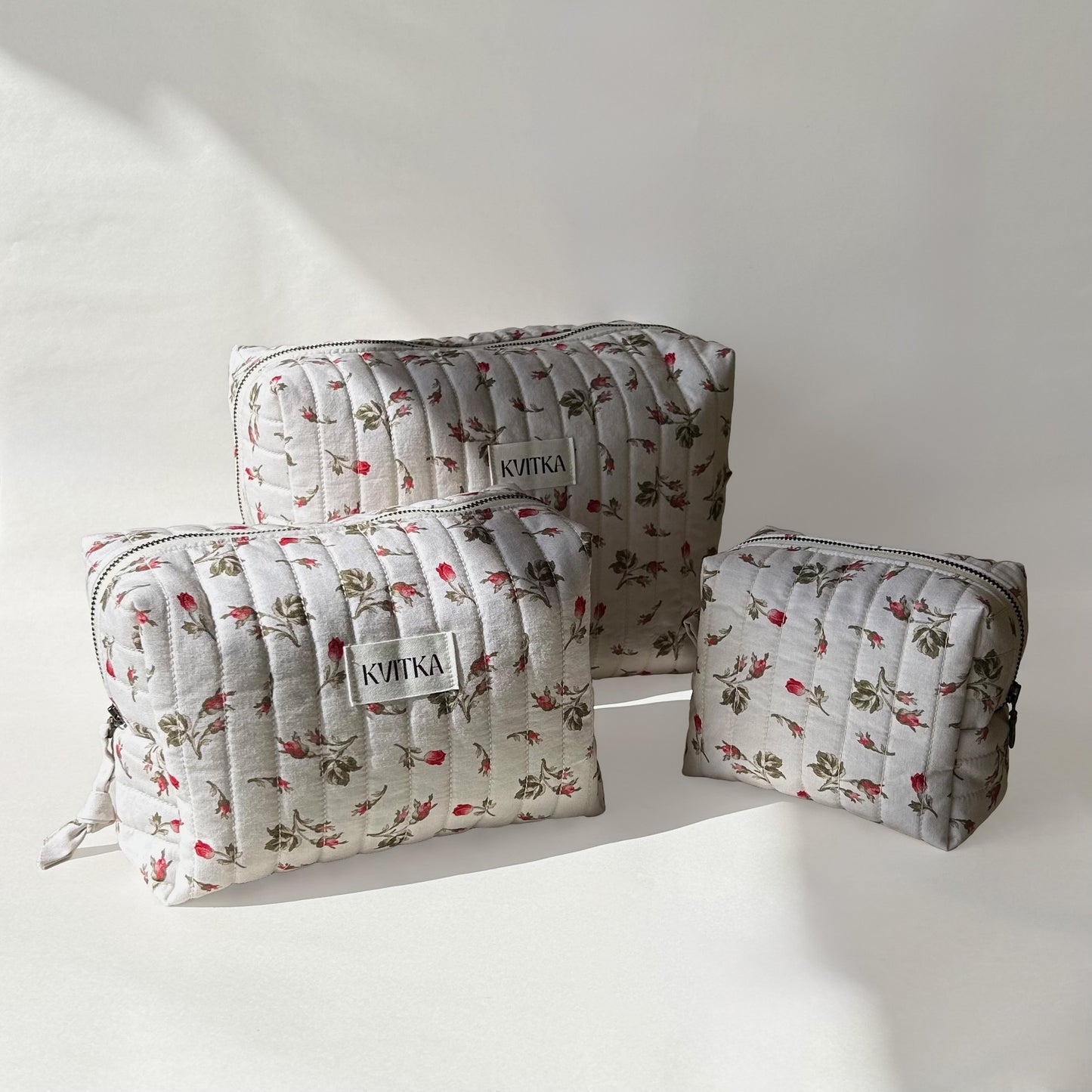 Set of three quilted makeup bags from the Bell Pivoines collection, shown in mini, medium, and large sizes, displayed at an angle on a soft white background.