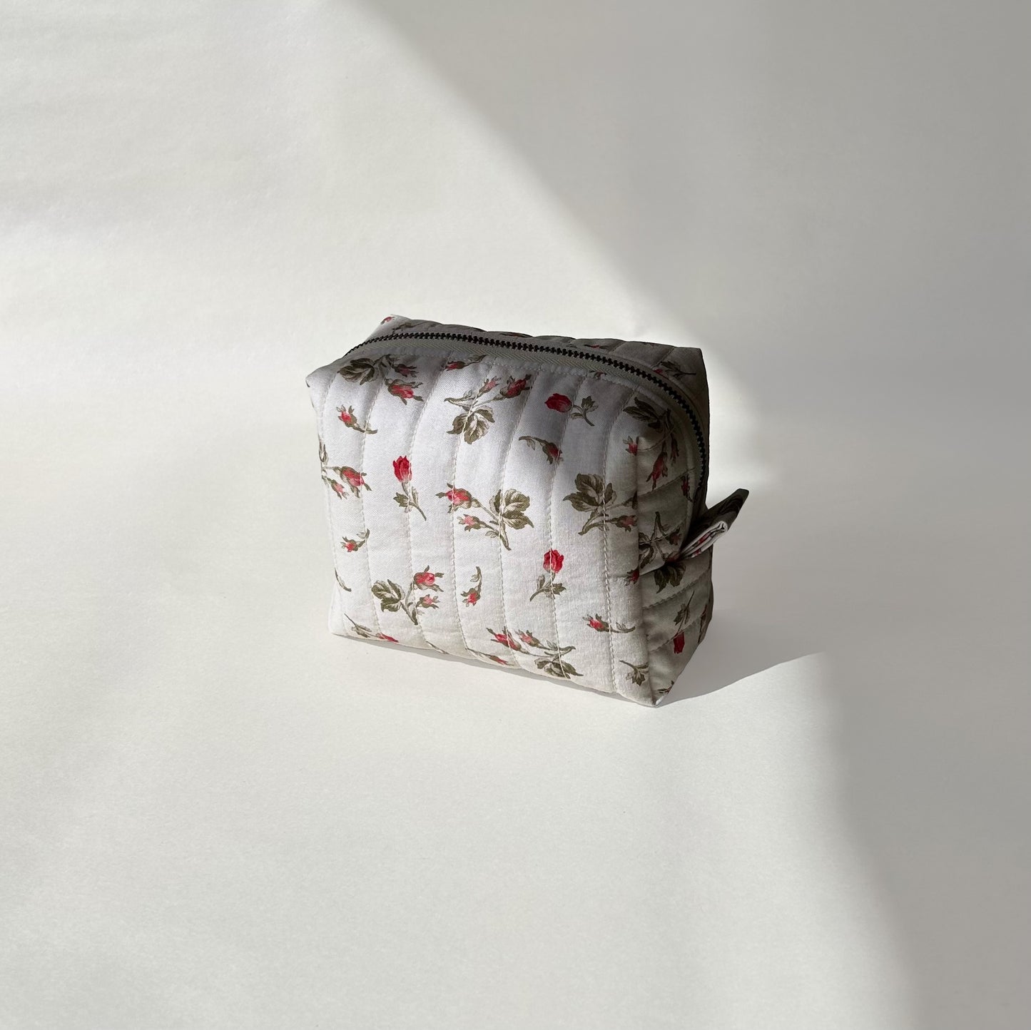 Mini-size of quilted makeup bag from the Bell Pivoines collection, angled to the right view on a soft white background.