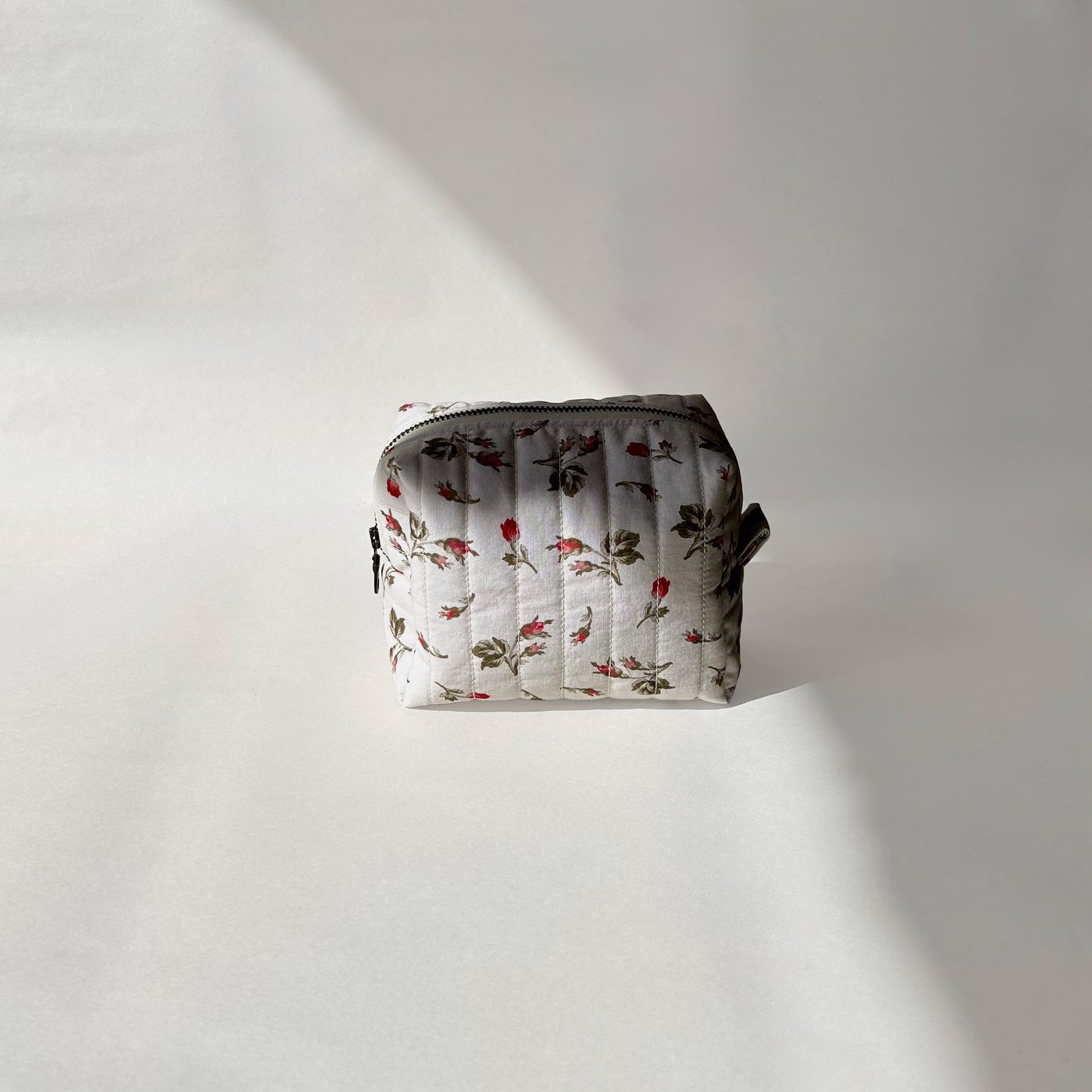 Mini-size of quilted makeup bag from the Bell Pivoines collection, displayed front-on view on a soft white background.