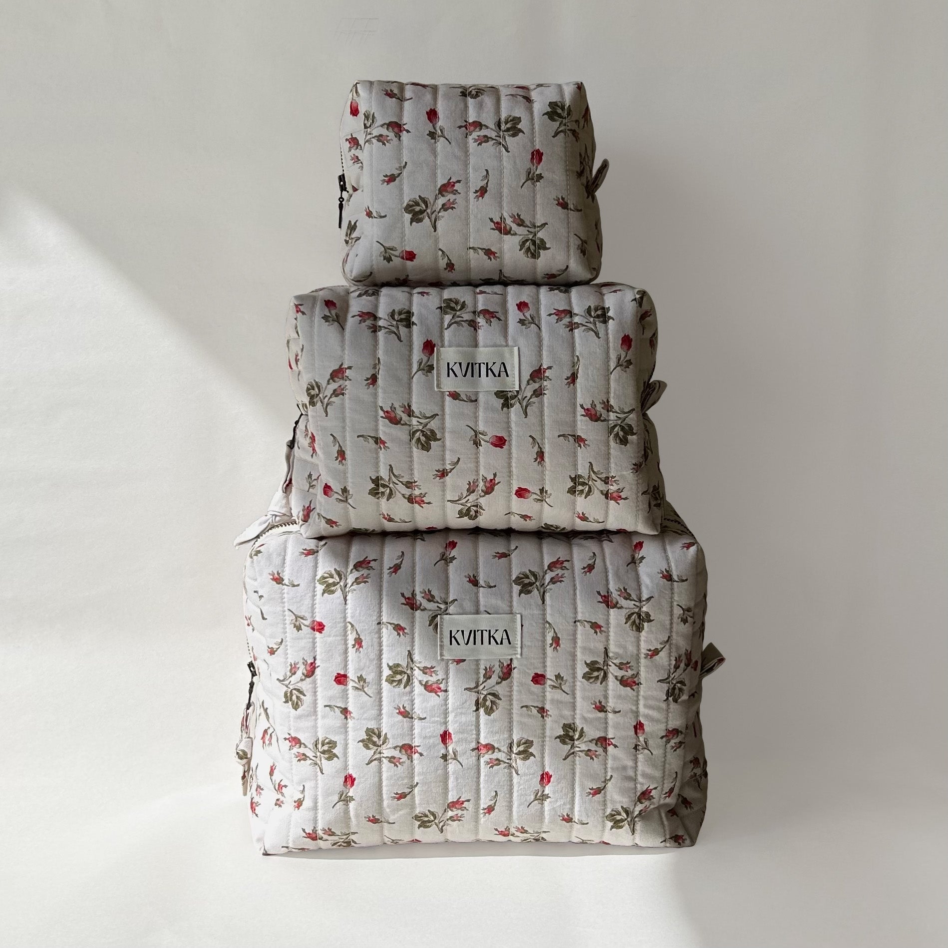 Set of three quilted makeup bags from the Bell Pivoines collection, shown in mini, medium, and large sizes, displayed on top of each other for size comparison on a soft white background.