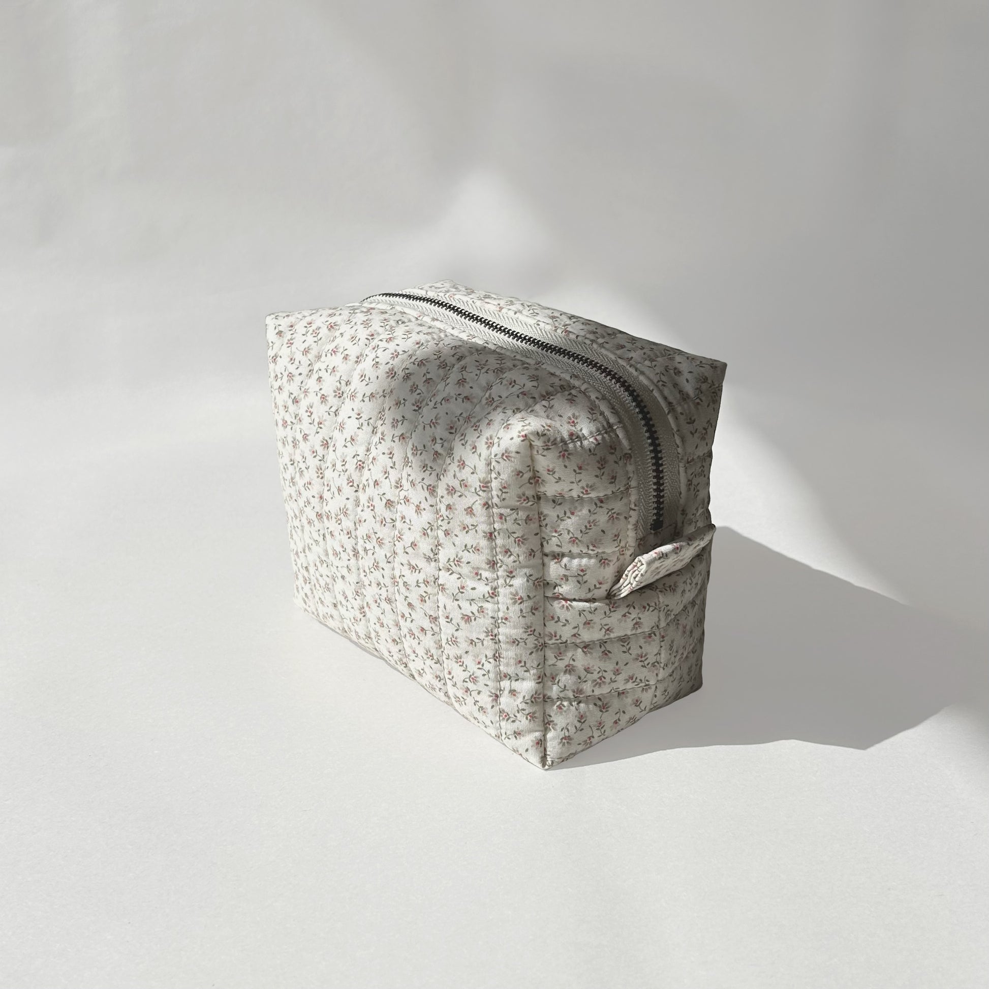 Mini-size of quilted makeup bag from the Ditsy Blossom collection, angled to the right view on a soft white background.
